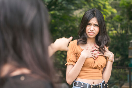 A young asian woman is insulted by accusations hurled on her by another girl. Standoff at a park.