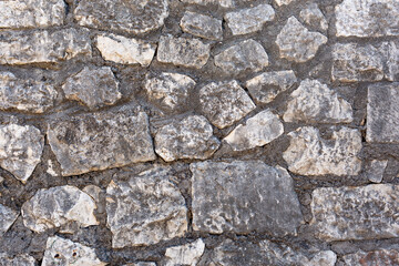 Old grungy retro dirty faded brick wall of ancient city. Uneven pitted peeled surface brickwork of cellar worn. Ruined shabby stiff blocks.Hard solid messy ragged holes brickwall of 3D grunge design.