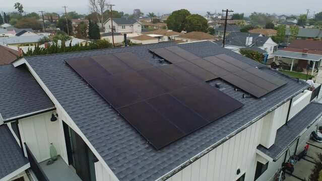 Aerial orbit around rooftop with solar panels installed on cloudy day Los Angeles, California
