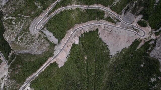 Drone video of previous revealing plane from a bird's eye view over the "Rrapsh Serpentine" mountain pass on the Sh20 road in Grabom, Albania, Leqet and Hotit can be seen circulating vehicles