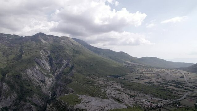 Frontal drone video over the "Rrapsh Serpentine" mountain pass on the Sh20 road in Grabom, Albania, Leqet e Hotit you can see village houses and vehicles