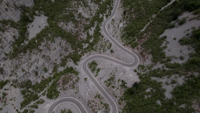 Drone video of a previous revealing plane on the Sh20 highway in Albania, at the height of Javor and Mreg, snake road, car can be seen circulating, cloudy sky