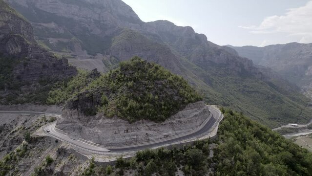 Drone video of empty description plane over the "Rrapsh Serpentine" mountain pass on the Sh20 road in Grabom Albania, you can see a motorcycle  and car passing by.
Leqet e Hotit