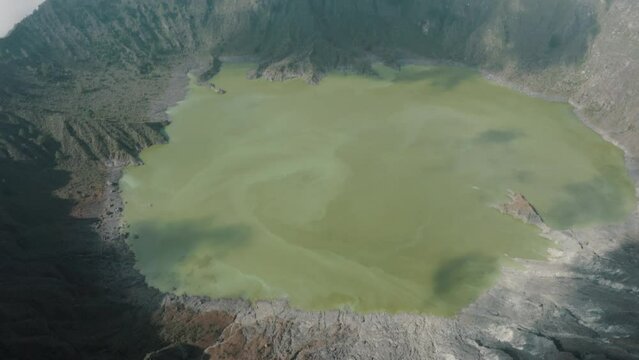 Aerial tilt up shot of majestic Volcano with tuff ring and green lake in the valley of crater lighting by sun - El Chich&oacute;n,Mexico