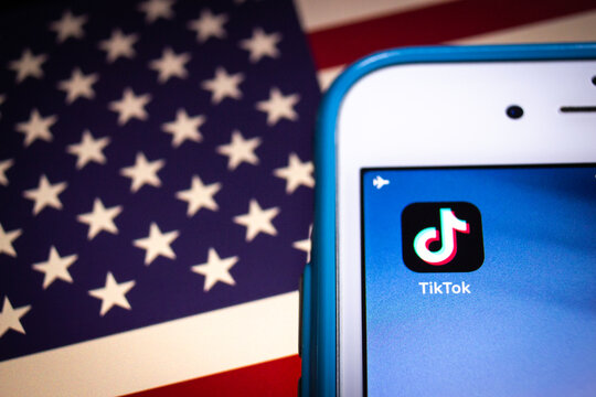 Kumamoto, Japan - Aug 11 2020 :.Concept image of TikTok, a Chinese video-sharing SNS by ByteDance in Beijing, on iPhone on US flag. President Trump signs executive order, essentially banning TikTok
