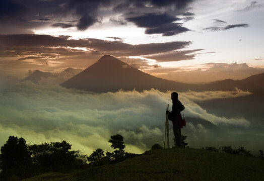 Sunset in the chain of volcanic mountains of the city of Antigua with a person in backlight