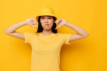 pretty brunette wearing a yellow hat posing emotions yellow background unaltered