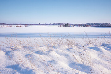 Fototapeta na wymiar A beautiful winter day landscape of rural area. Snowy scenery of Northern Europe.