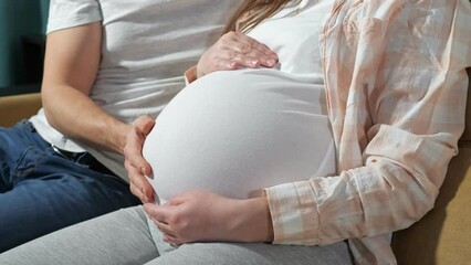 couple family future expecting parents sitting on couch , man stroking wife's pregnant belly with cute small childish. - Powered by Adobe