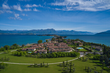 Fototapeta na wymiar Panoramic aerial view of the Sirmione peninsula on Lake Garda, Italy. Parco San Vito in Colombare, Sirmione. Sirmione, lake garda in the background of the alps.