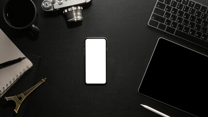 Modern black workstation top view with smartphone blank screen