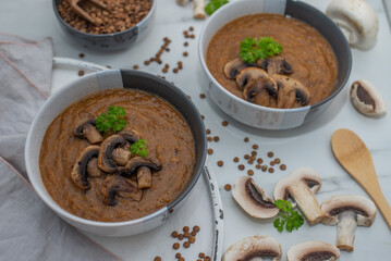 Mushroom soup of champignons and lentils in a bowl