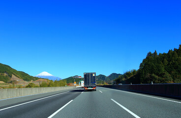 高速道路を走行するトラックと富士山