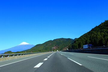 高速道路を走行するトラックと富士山