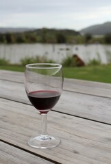 glass of red wine on a table in a garden with beautiful view 