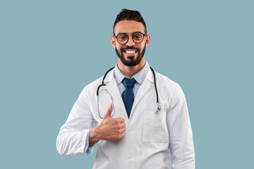Cheerful Arabic Male Physician Gesturing Thumbs Up, Studio Shot