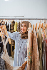 Fototapeta na wymiar Successful muslim fashion designer checking at her product