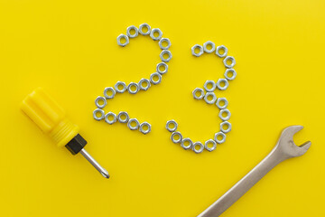 The number 23 of nuts with screwdriver and wrench on a yellow background. Defender of the...