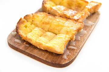 Bread toast and condensed milk on wooden plate