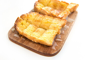 Bread toast and condensed milk on wooden plate