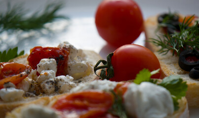 Bruschetta with tomatoes, herbs, cottage cheese, ground pepper, olives. Close-up.
