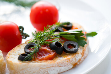 Bruschetta with tomatoes, herbs, olives. Close-up.