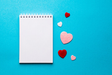 Valentine's day composition with notebook list and hearts on blue background. Wedding, birthday,...