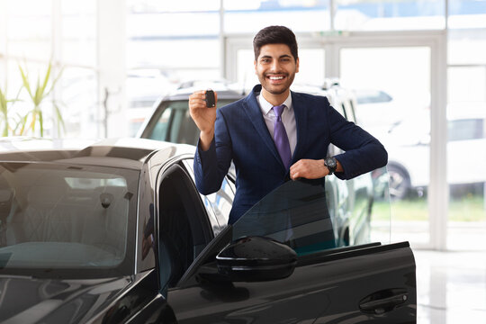 Middle-eastern businessman showing car key and smiling