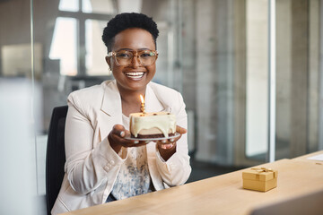 Happy African American businesswoman with her Birthday cake in the office looks at camera. - Powered by Adobe