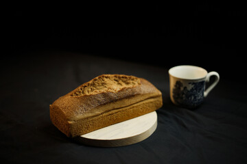 bread on a wooden plate on a black background