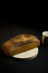 bread on a wooden plate on a black background