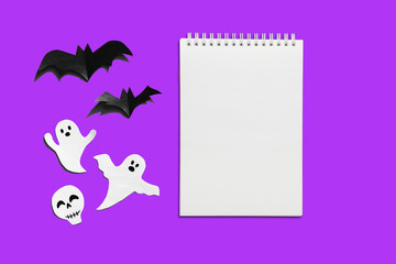 Halloween set decorations with ghost, bat and mock up notebook list on violet very peri background. Holiday party, minimal card, spooky concept. flat lay, copy space, top view, place for text