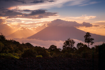 Sea of clouds with sunset in volcanic mountain range of Antigua, Guatemala