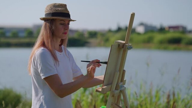Female painter painting before nature