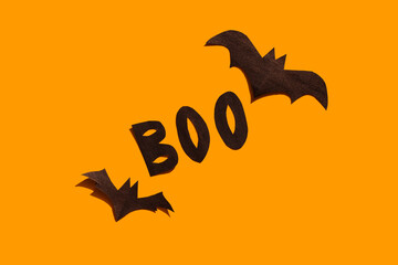 Halloween set decorations with bats and word BOO on orange background. Holiday party, minimal greeting card, spooky concept. flat lay, copy space, top view, place for text