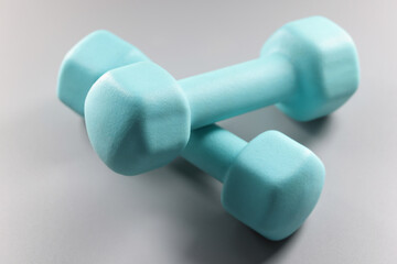 Pair of blue dumbbells on grey surface, planning weight loss, equipment for sport activity