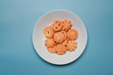 Above view plate with Danish butter cookies on blue background.