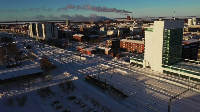Aerial view of the Oulu railway station, winter sunrise, in Finland - descending, drone shot