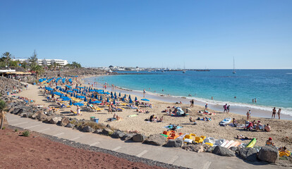 Playa Blanca, Lanzarote (Spain) on Januari 23, 2022: Tourist enjoying the beach and sun during the winter period