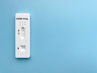 Positive rapid test result for Covid-19. Close-up of a device for the rapid detection of coronavirus (sars-CoV-2) antigen.  Isolate On a blue background, top view, flat lay, copy space.