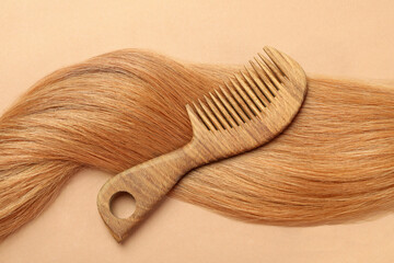 Female hair with hairbrush on beige background