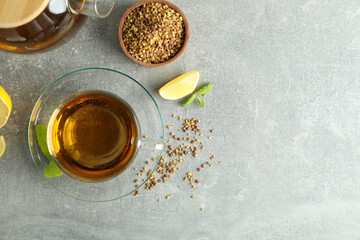 Concept of hot drink with buckwheat tea on gray textured background