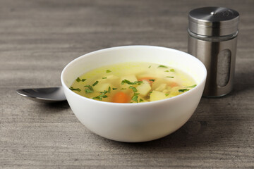 Concept of tasty food with chicken soup on gray textured background