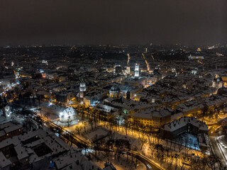 Fototapeta na wymiar Aerial shot of Old City Lviv cowered by snow with churches and cathedrals.