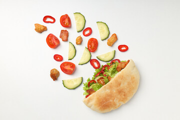 Pita with chicken, and ingredients on white background
