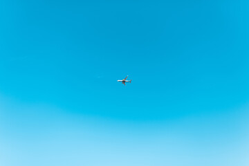 Fototapeta premium Beautiful clear blue sky with a plane high in the sky. Travel concept