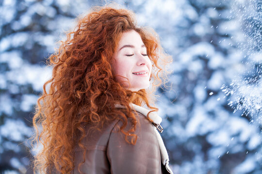 Portrait of a young beautiful woman in a winter park