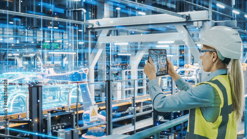 Leinwandbilder Futuristic Car Factory Digitalization Industry 4.0: Female Automotive Engineer Using Augmented Reality Tablet Computer to Scan Automated Robot Arm Assembly Line Manufacturing Electric Vehicles