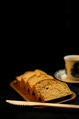 slices of bread on a wooden plate on a black background