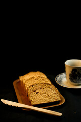 slices of bread on a wooden plate on a black background